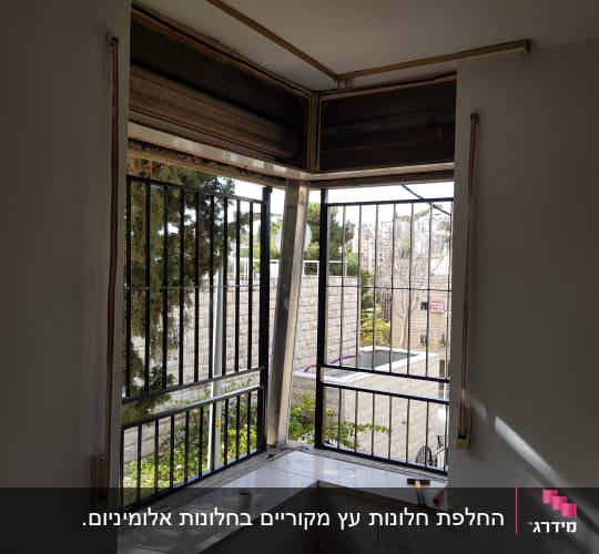 חלון עם מסגרת אלומיניום ותריסים פתוחים